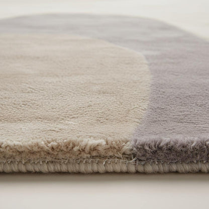 Abstract neutral area rug with organic shape and beige cream tones, modern minimalist living room carpet.