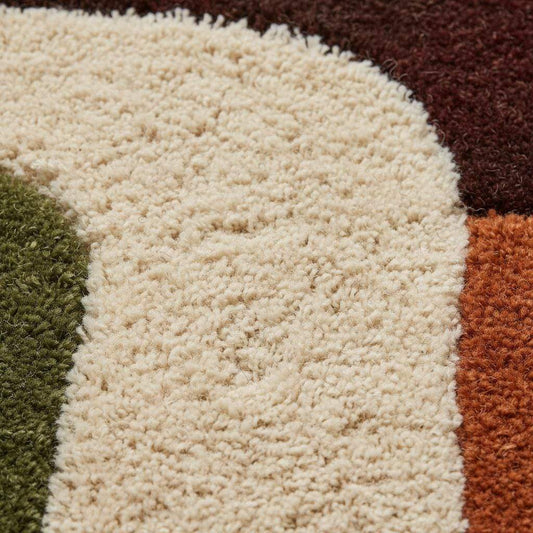 Close-up detail of a handmade tufted rug showing textured wool and stitching