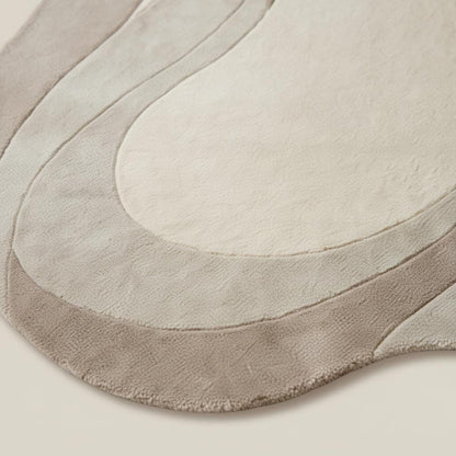 Neutral wavy area rug with sculpted curved abstract design and plush soft texture for modern living rooms