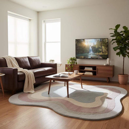 Soft wool handmade rug with flowing layered shapes in beige, mauve, and blue tones, styled under natural window light.