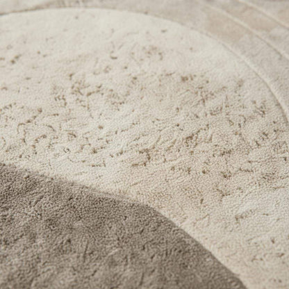Round sculpted wool rug with textured surface in neutral beige for minimalist living room decor