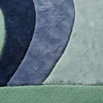 Modern abstract wave rug with sculpted pile in mint, navy, and blue tones for modern and mid century home decor