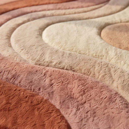 Modern boho area rug with abstract wave design in earth tones for living room decor