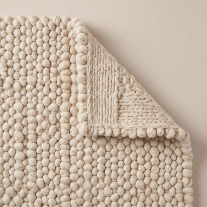 Handwoven chunky wool pebble rug in cream with textured, soft felted wool balls for minimalist Scandinavian home decor