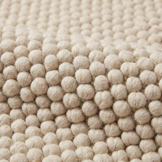 Handwoven chunky wool pebble rug in cream with textured pebble design, ideal for minimalist Scandinavian home decor