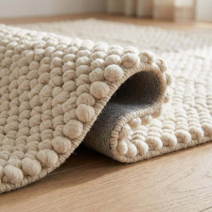 Handwoven chunky wool pebble rug in cream with textured pebble design for minimalist Scandinavian home decor