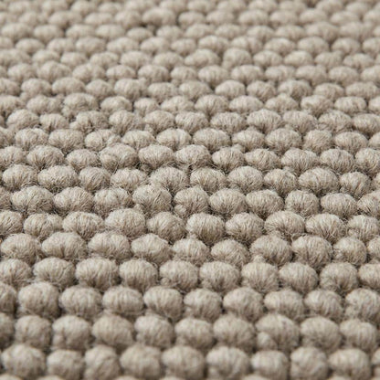 Chunky wool rug with thick loop weave in neutral beige, minimalist Scandinavian style living room decor