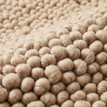 Chunky wool rug with thick loop pile in neutral beige, handwoven textured cozy living room carpet