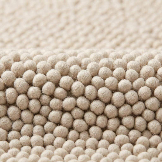 Chunky wool rug with thick handwoven loop pile in neutral cream for cozy minimalist home decor