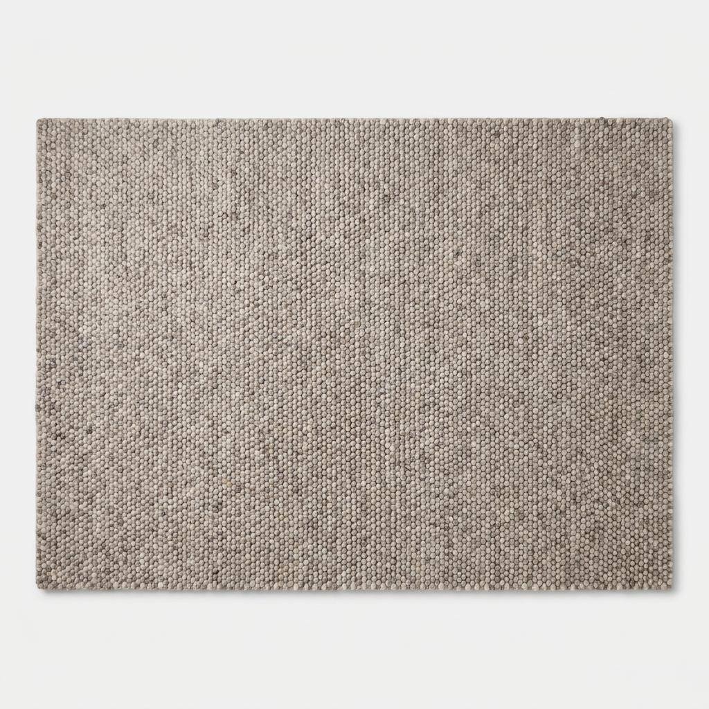 Chunky wool area rug in neutral beige with thick textured weave for cozy minimalist living room decor