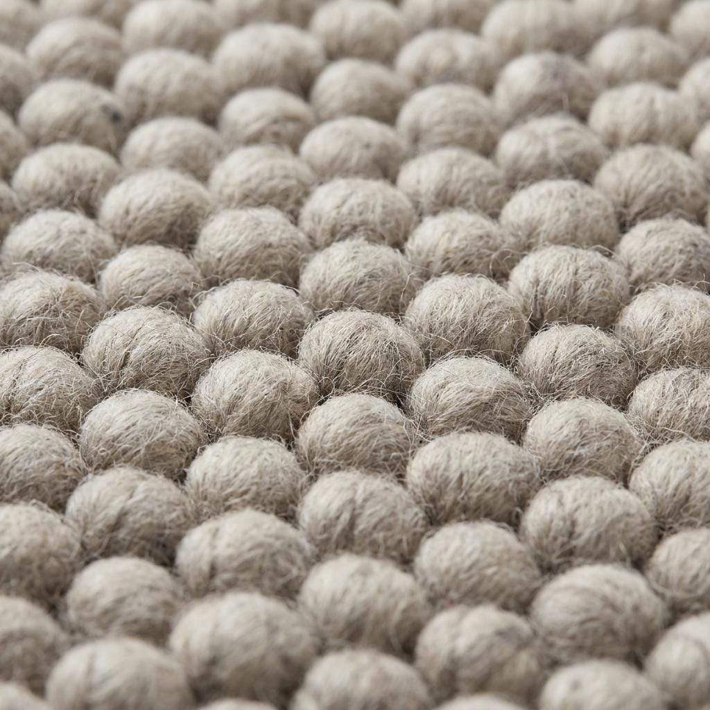 Chunky wool area rug in neutral beige with thick textured weave for cozy minimalist living room decor