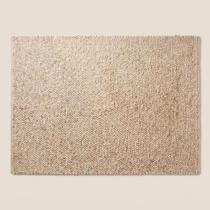 Chunky wool pebble rug in neutral beige with textured pebble weave, minimalist modern living room décor