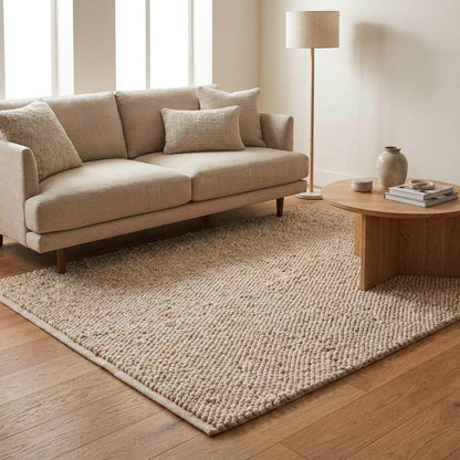 Chunky wool pebble rug in neutral beige with handwoven pebble texture in minimalist modern living room setting