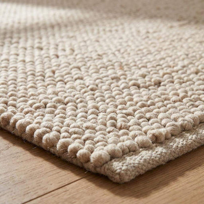 Chunky wool pebble rug in neutral beige with textured handwoven design for minimalist modern living room decor
