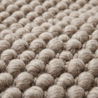 Handmade chunky wool rug with neutral pebble weave in Scandinavian minimalist Japandi style for cozy living room decor