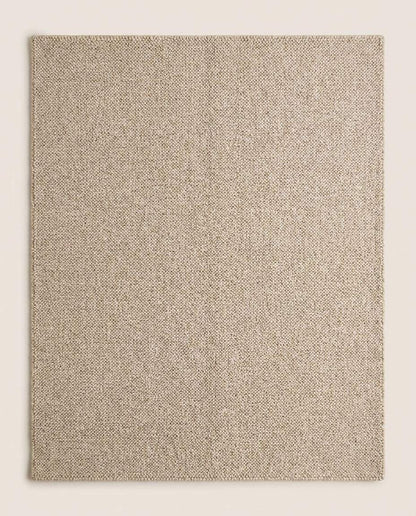 Chunky wool loop rug in neutral beige on wooden floor showcasing textured handmade cozy minimalist area rug