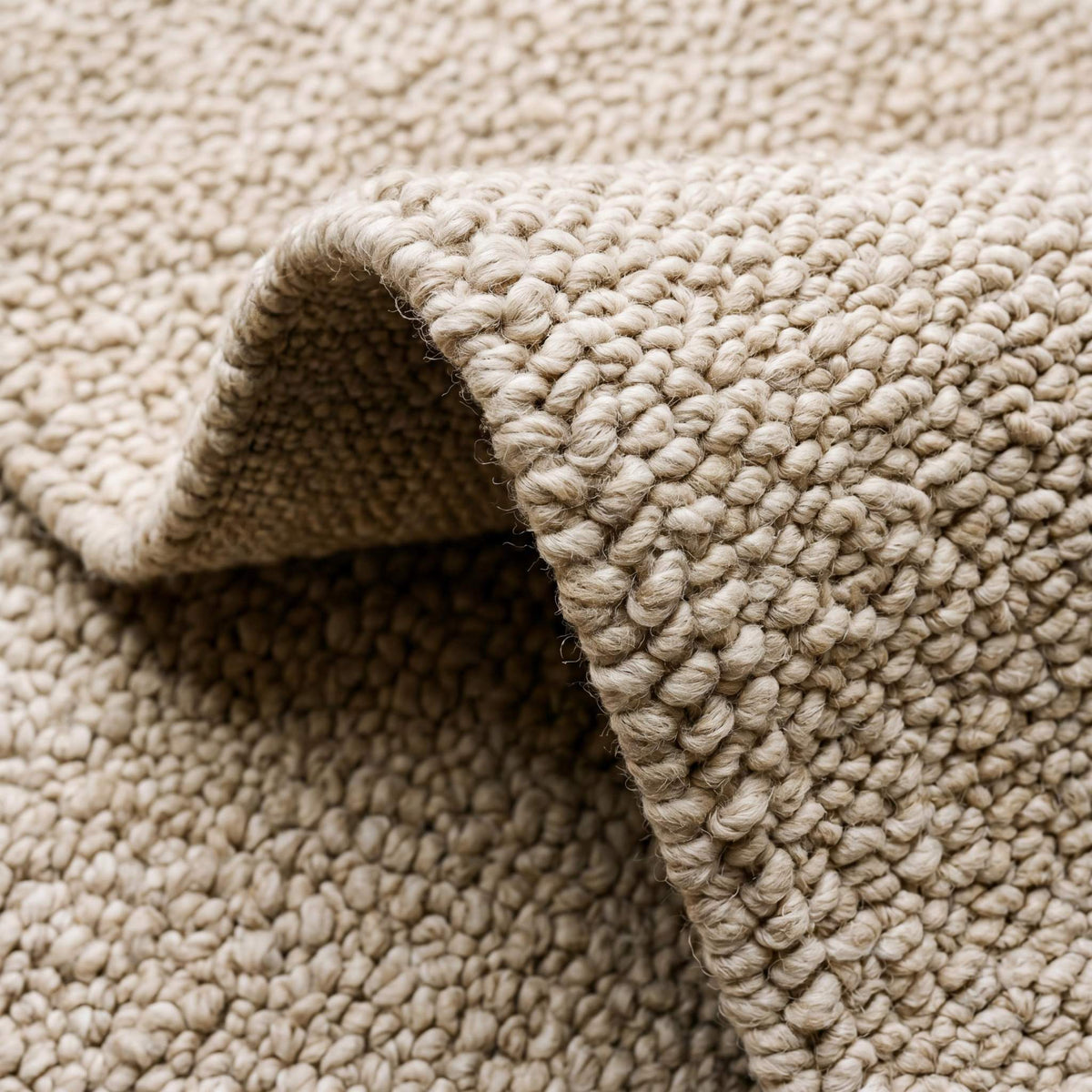 Neutral beige chunky wool loop rug with thick textured weave in minimalist modern room