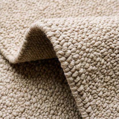 Neutral beige chunky wool loop rug with thick textured weave in minimalist modern room