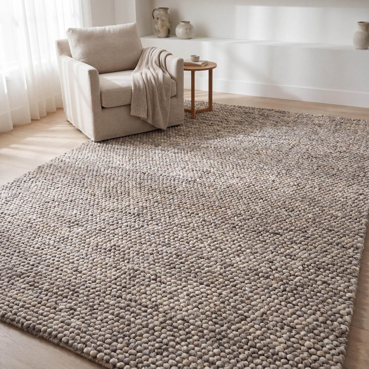 Chunky wool area rug in neutral beige with thick textured weave for cozy minimalist living room decor