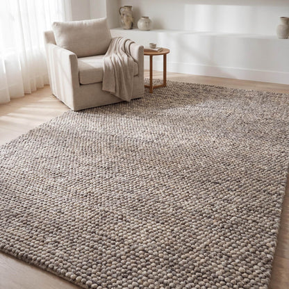Chunky wool area rug in neutral beige with thick textured weave for cozy minimalist living room decor