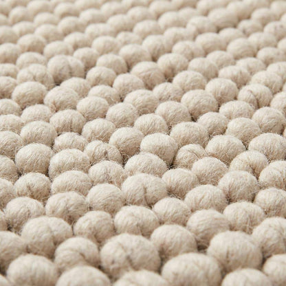 Handmade chunky wool rug with felt ball texture in neutral beige and cream tones for modern farmhouse decor