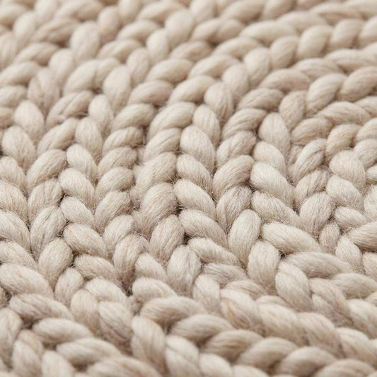 Round chunky knit wool rug in cream, handwoven Merino wool with Scandinavian minimalist design for cozy nursery or living room decor