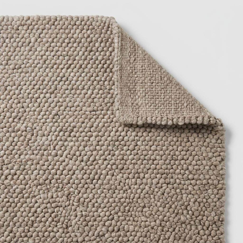 Handmade chunky wool rug with neutral pebble weave, Scandinavian minimalist design for cozy living room decor