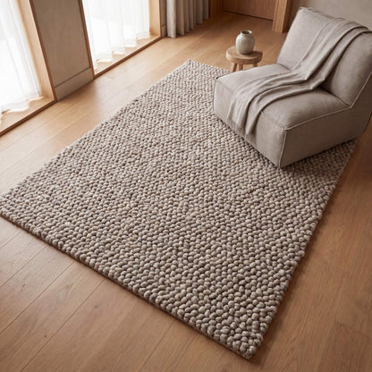 Handmade chunky wool rug with neutral pebble weave in Scandinavian minimalist Japandi style for cozy living room decor