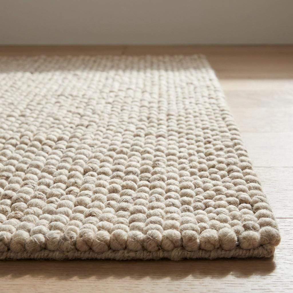 Handmade chunky wool rug with neutral beige and cream felt balls for modern farmhouse decor