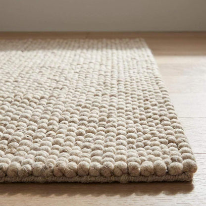 Handmade chunky wool rug with neutral beige and cream felt balls for modern farmhouse decor