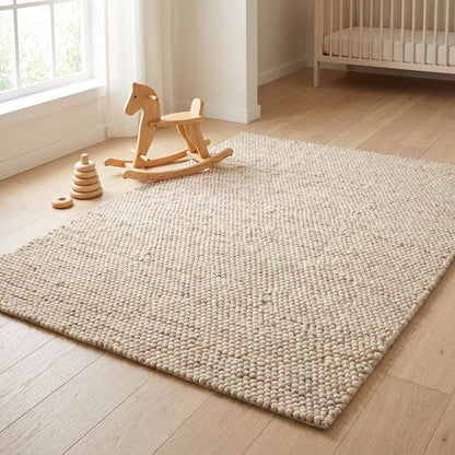 Chunky wool rug handmade from felt balls in neutral beige and cream tones for modern farmhouse decor