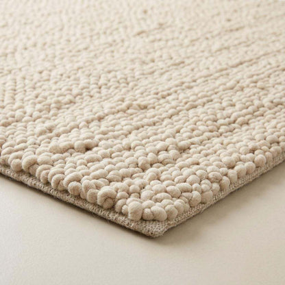 Handwoven chunky wool pebble rug in natural ivory with thick texture for modern nursery and living room interiors