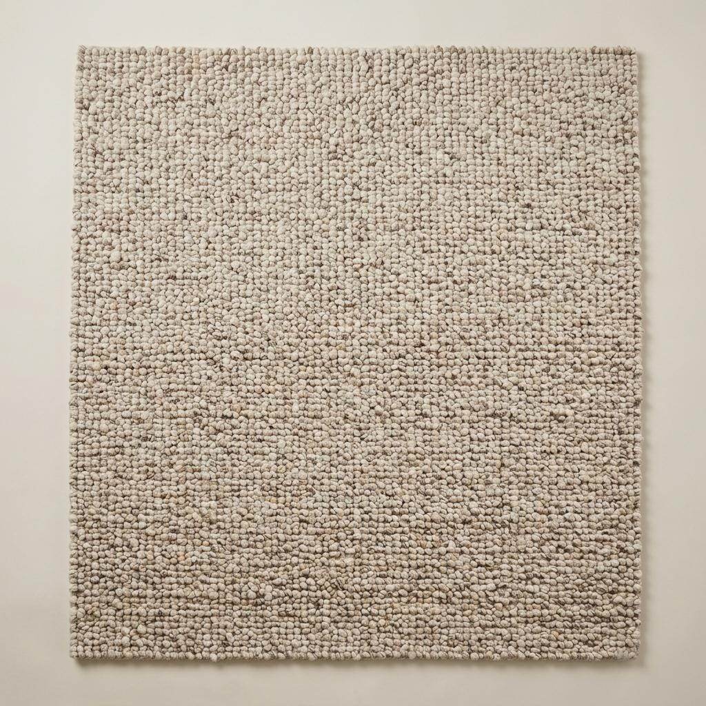 Handwoven chunky wool rug with natural beige pebble texture in Scandinavian living room setting