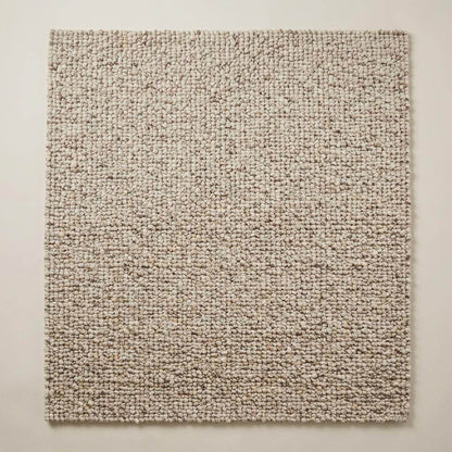 Handwoven chunky wool rug with natural beige pebble texture in Scandinavian living room setting