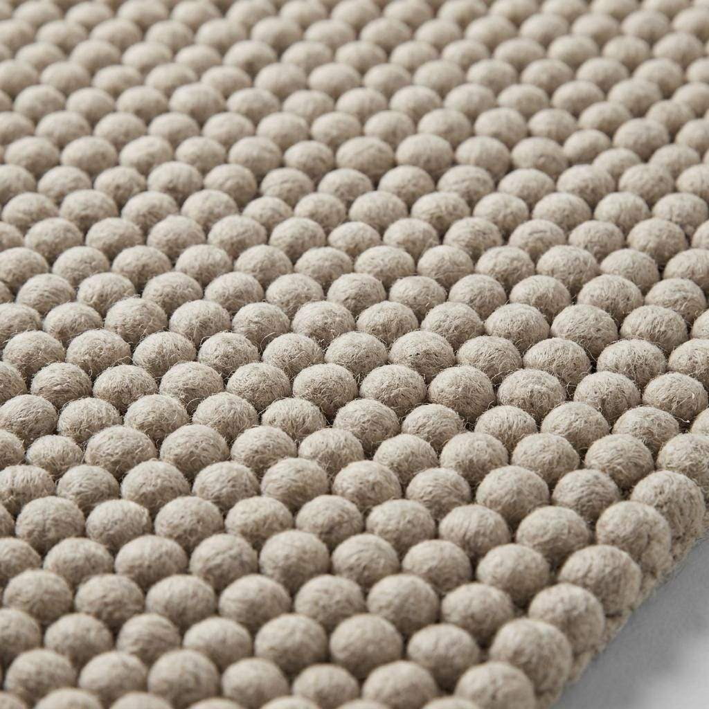 Handwoven chunky wool pebble rug in neutral beige with thick texture for Scandinavian modern decor