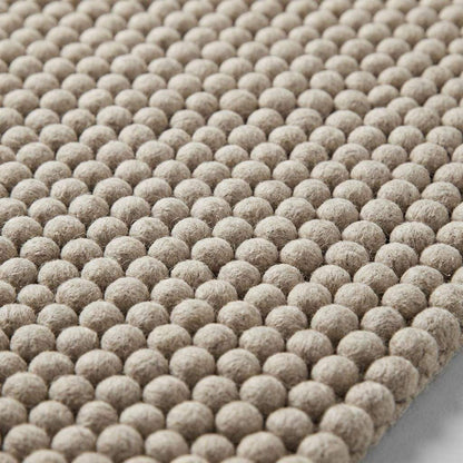 Handwoven chunky wool pebble rug in neutral beige with thick texture for Scandinavian modern decor