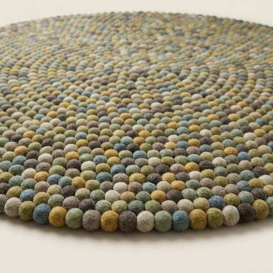 Handmade wool felt ball rug in sage green with earthy tones for nursery and playroom decor