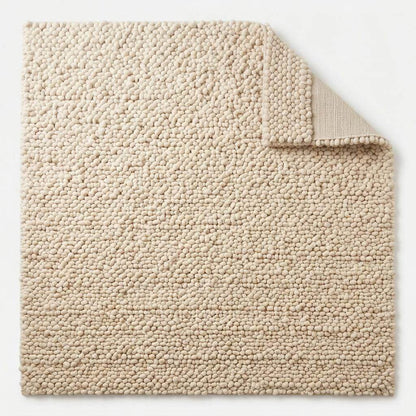 Handwoven chunky wool pebble rug in natural ivory with thick texture for modern nursery and living room interiors