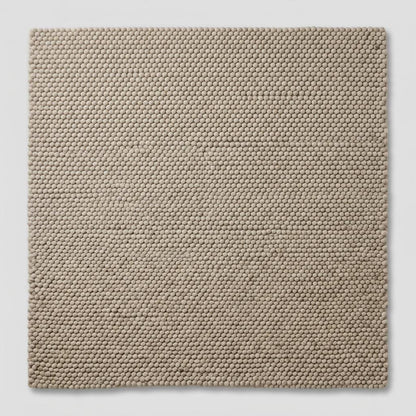 Handwoven chunky wool pebble rug in neutral beige with thick texture for Scandinavian modern decor