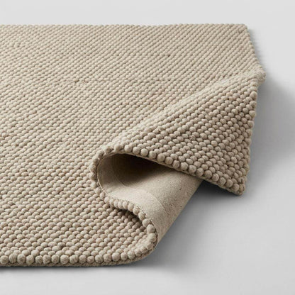 Handwoven chunky wool pebble rug in neutral beige, soft and thick texture for Scandinavian modern decor