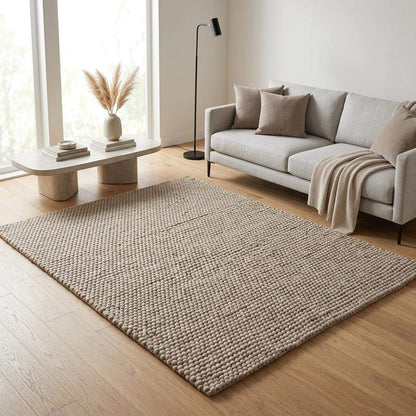 Handwoven chunky wool pebble rug in neutral beige with thick texture for Scandinavian modern decor
