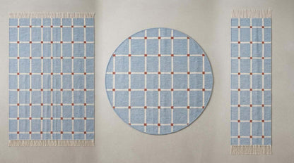 Handwoven flatweave blue grid rug with terracotta accents in modern farmhouse living room