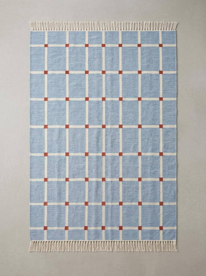 Handwoven flatweave blue grid rug with terracotta accents for modern farmhouse living room