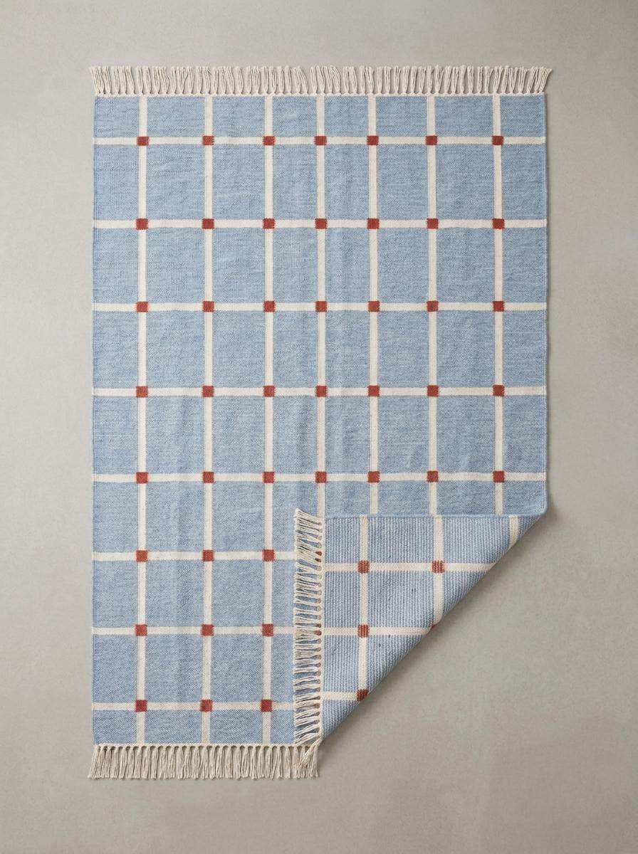 Handwoven flatweave blue grid rug with terracotta accents in modern farmhouse living room