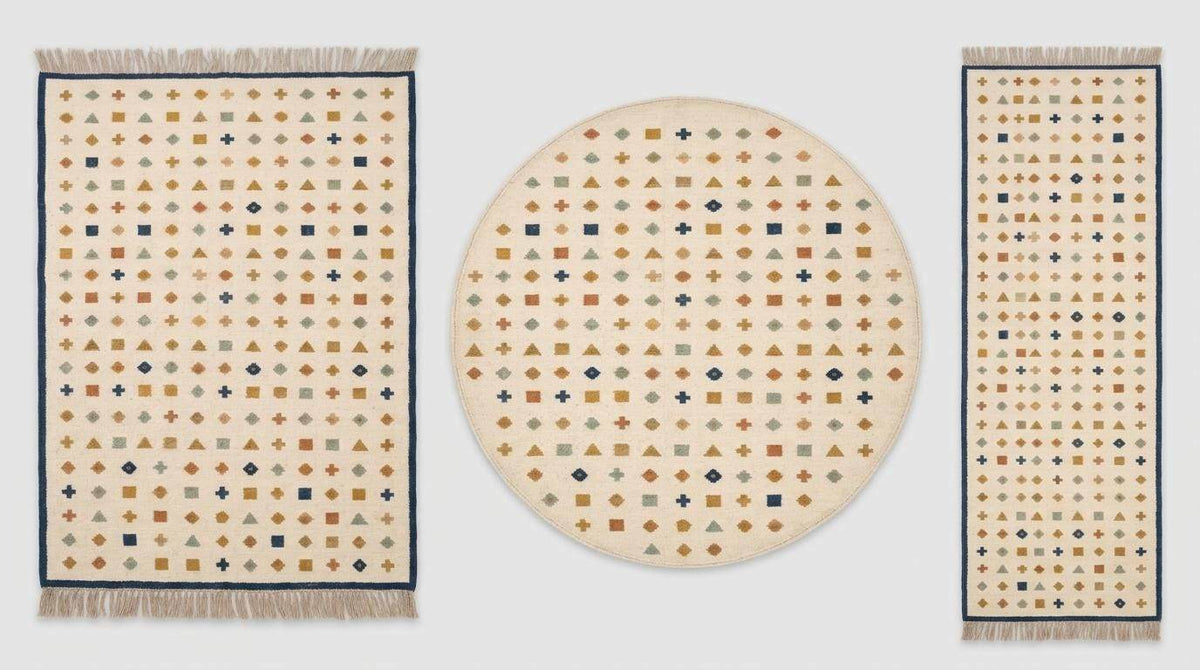 Ivory wool flatweave kilim rug with navy border and geometric motifs in living room