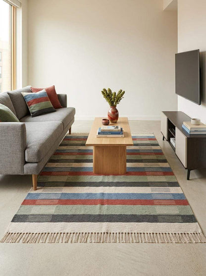 Handwoven striped wool flatweave rug in blue, rust, sage green, and ivory with cotton fringe