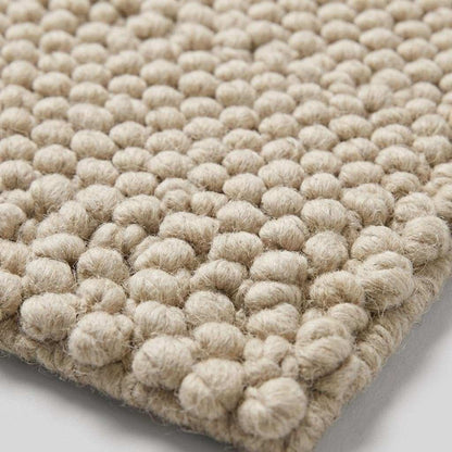 Handwoven chunky wool pebble rug in ivory with textured minimalist design for modern home decor