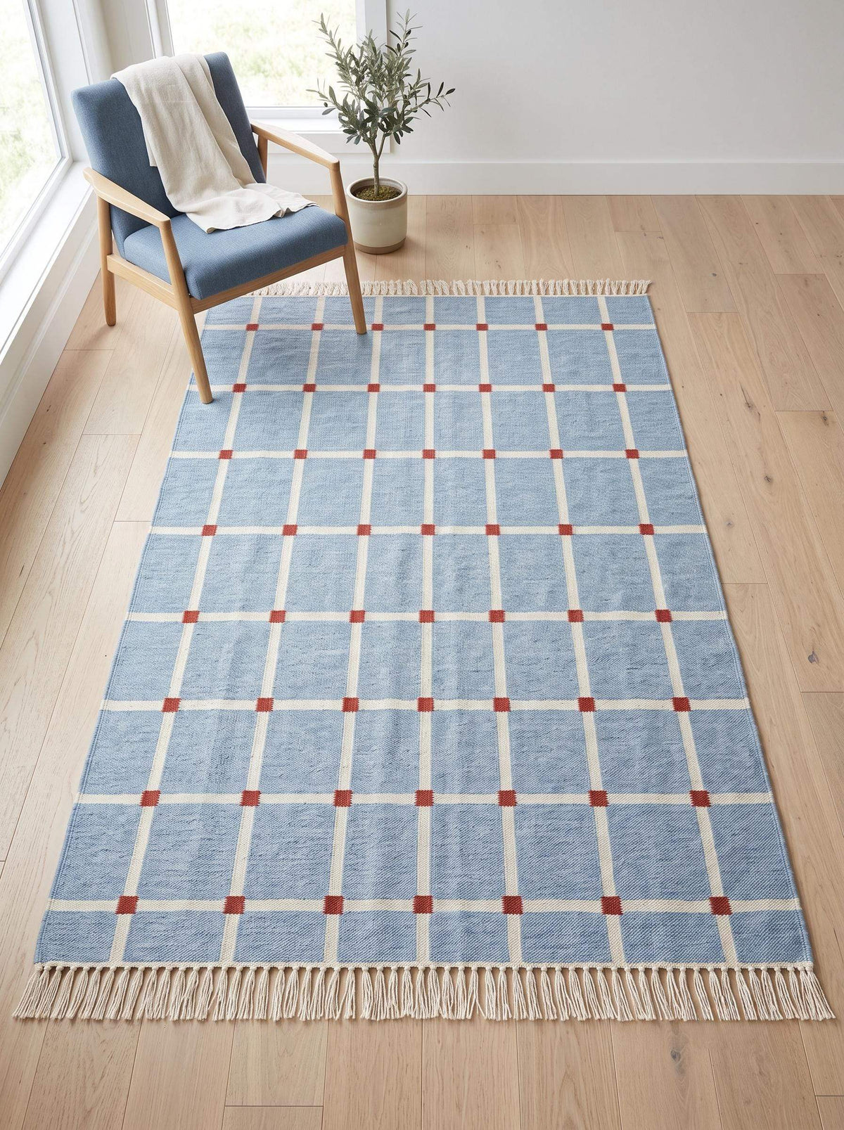 Handwoven flatweave blue grid rug with terracotta accents in modern farmhouse living room