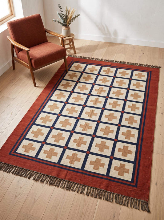 Handwoven flatweave wool rug with southwestern cross geometric design in rust and navy colors