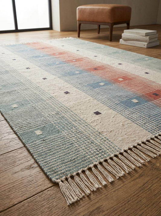 Handwoven tartan flatweave rug in sage green and terracotta with Scandinavian modern plaid design